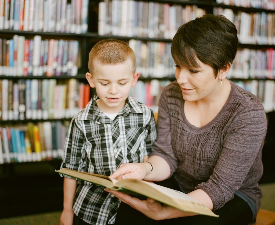 Vuxen läser en bok tillsammans med ett barn i ett bibliotek